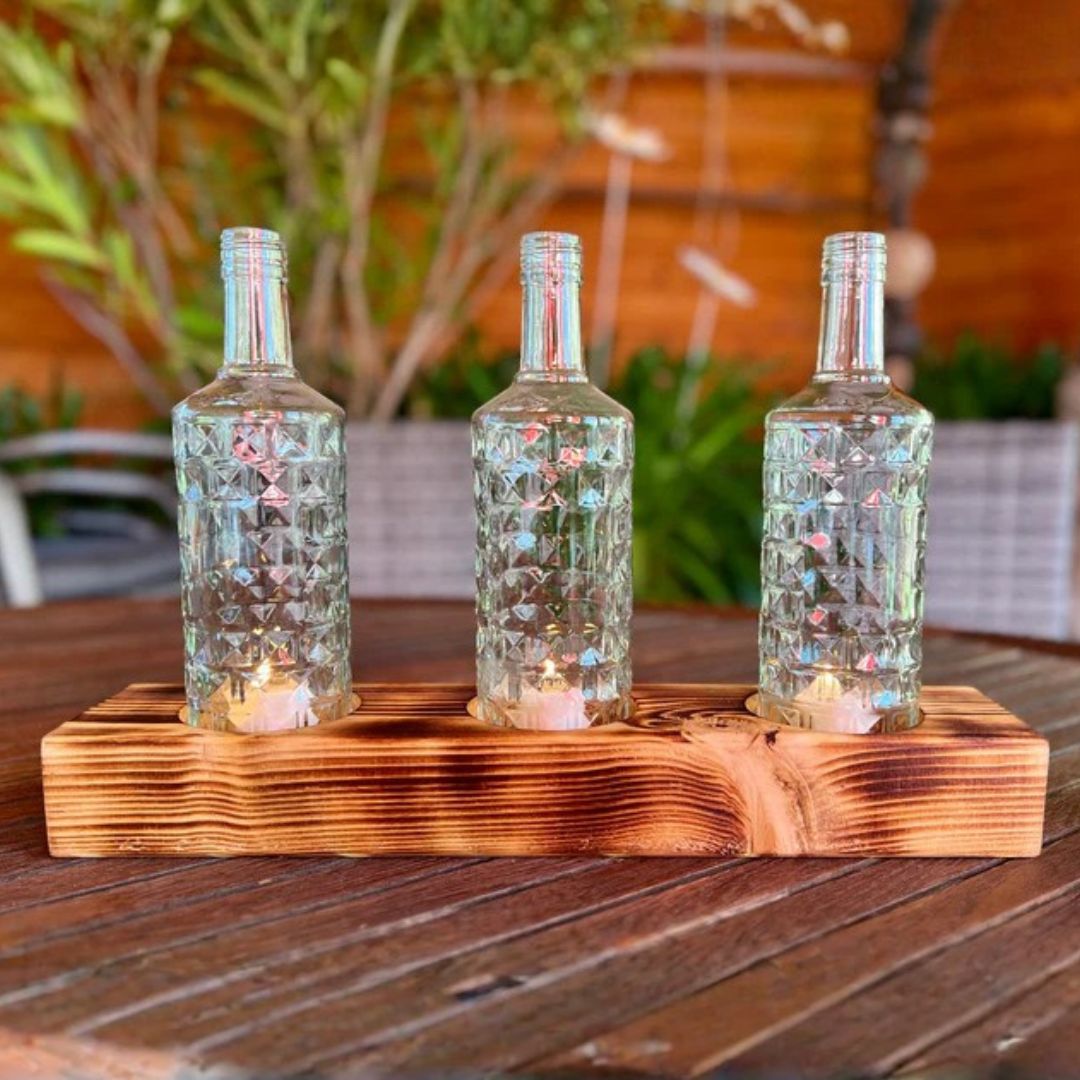 Triple candle holder made from recycled bottles with a wooden base