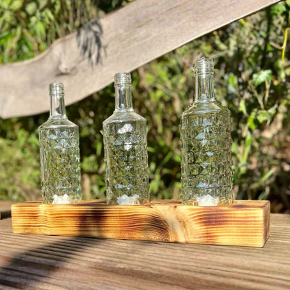 Triple candle holder made from recycled bottles with a wooden base